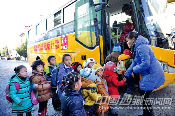西藏2013年1月1日起校車擁有優(yōu)先通行權(quán)/ 幼兒園老師正在組織學(xué)生上校車。