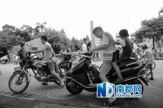<p>因校車座位不夠，洪梅第二小學今年的新莞人新生不能坐校車，許多家長只能騎車接送孩子。南都記者劉在富攝<br /><br /></p>