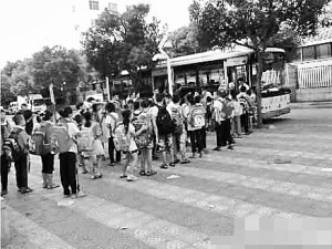 集美潤(rùn)澤小學(xué)公交當(dāng)校車 30多座位擠進(jìn)79名學(xué)生 孩子們?cè)谂抨?duì)上車。網(wǎng)友供圖