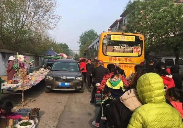 青州這所學校門口全是擺攤的，校車都堵了...