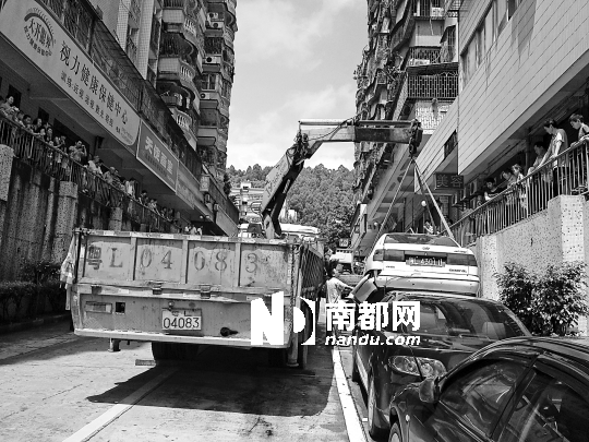 <p>交警正在用吊車把被撞的小轎車拖走。南都記者李立君攝<br /></p>