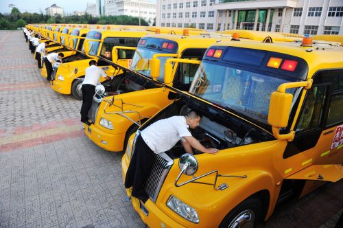 交運溫馨校車黃島分公司駕駛員在檢查和清理校車發(fā)動機。 (1)