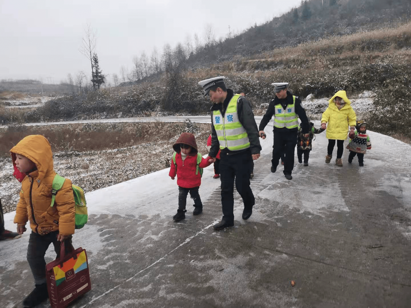 路面冰凍打滑校車受阻，警察“叔叔”牽著13個(gè)孩子回家