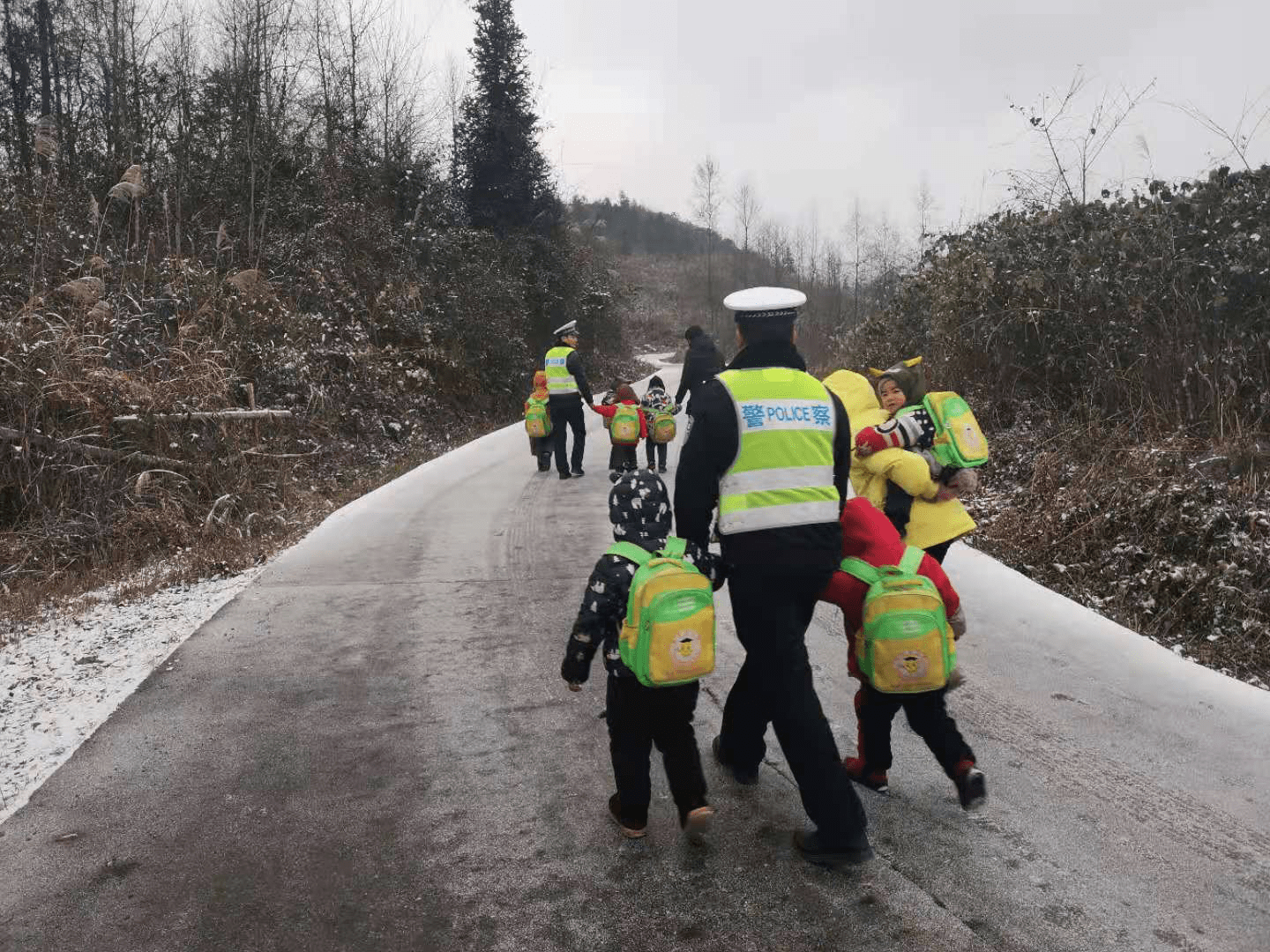 路面冰凍打滑校車受阻，警察“叔叔”牽著13個(gè)孩子回家